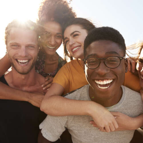 a group of young people smiling after having metal free dental implants