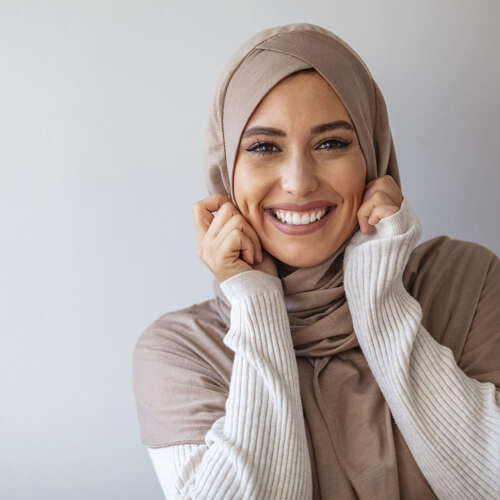 women with head scarf smiling