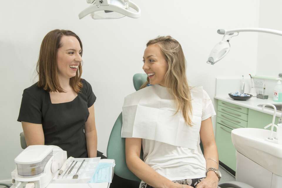 Two girls talking in a dentist chair