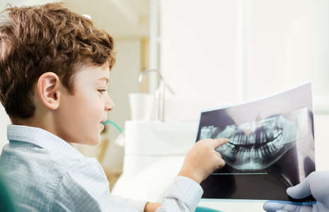 a young boy patient looking at an x-ray of his teeth at progressive dentistry