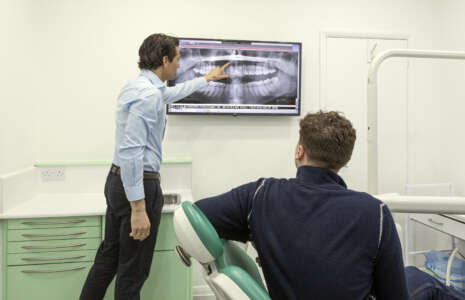 dr nissit patel showing teeth straightening treatment to a patient at progressive dentistry