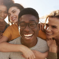A group of young people smiling after having metal free dental implants close up