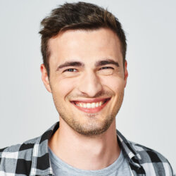 Man with check shirt white teeth smiling close up