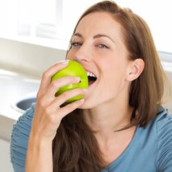 Women biting an apple close up